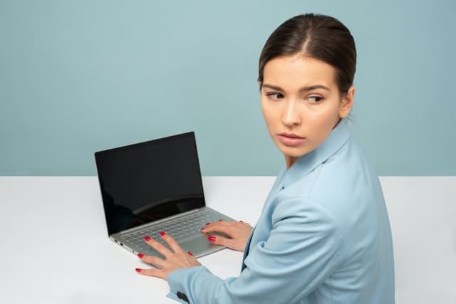 vrouw met laptop kijkt achterom