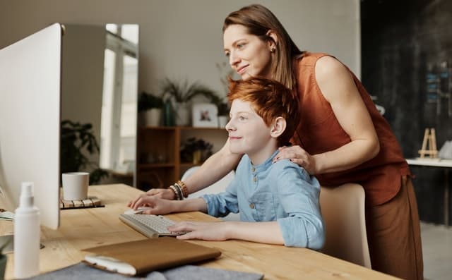 kind en moder achter computer